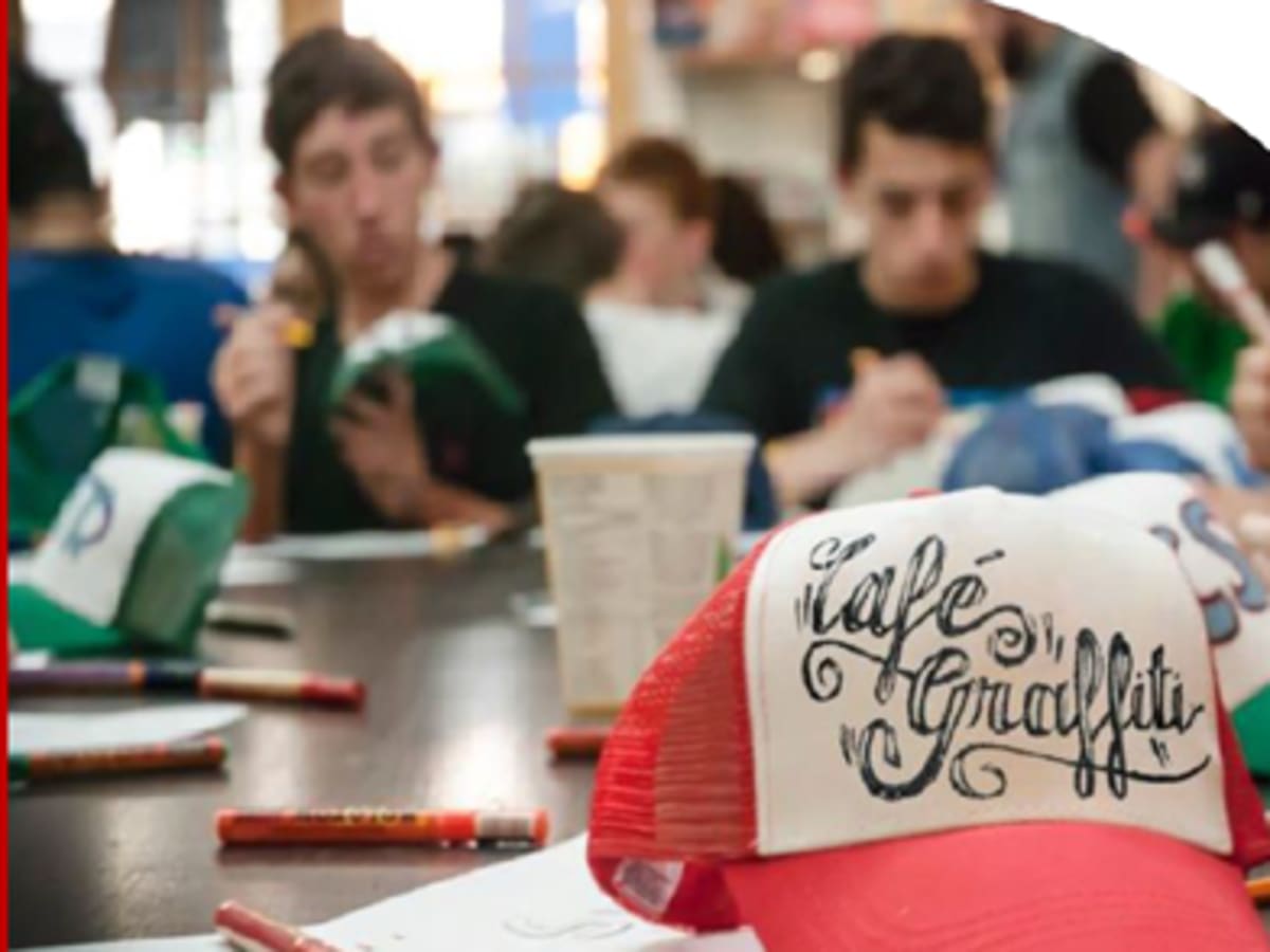 Photo d'une casquette rouge et blanche avec 'Café Graffiti' écrit dessus