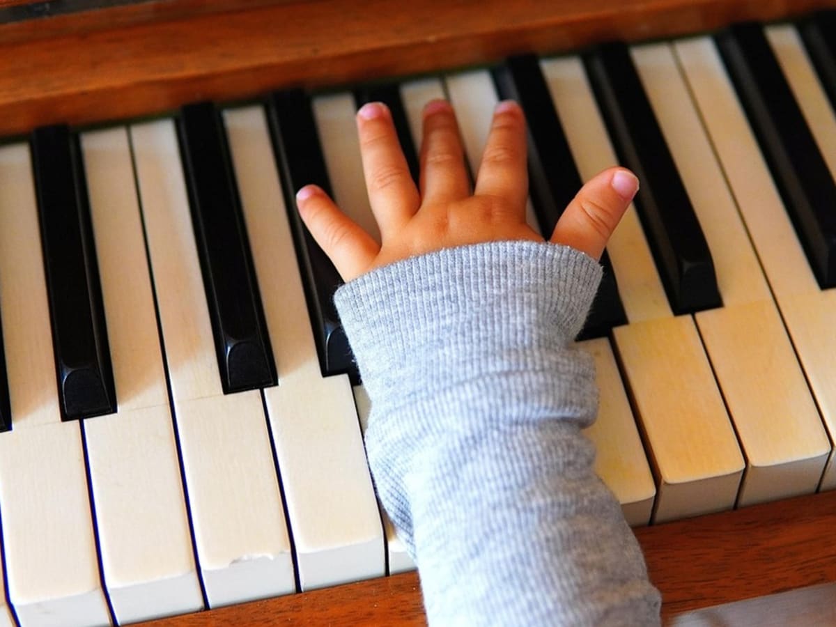 Main d'enfant sur un piano.