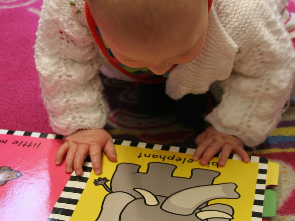 Un bébé avec un livre.