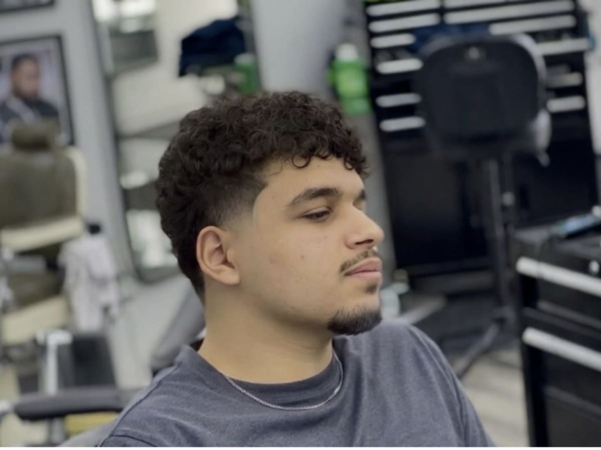Une photo d'un adolescent avec une nouvelle coupe de cheveux à un barbier