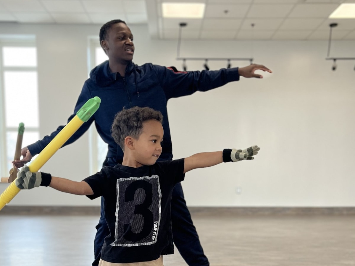 Deux enfants dans une salle de sport sur le point de lancer un javelot.
