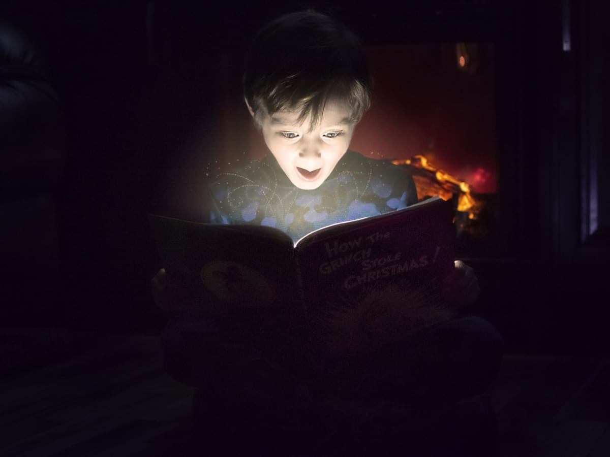 Enfant qui regarde un livre magique