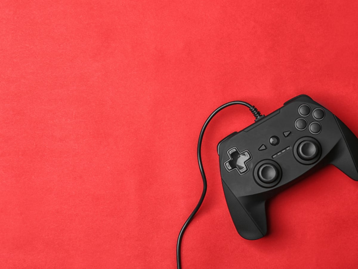 Une manette de jeu vidéo sur un fond rouge.