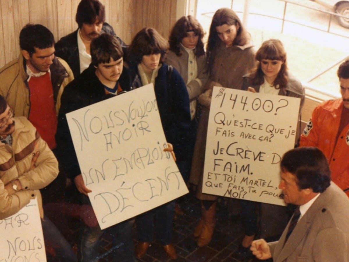Image d'archive, de jeunes étudiants de la JOC brandissent des pancartes devant un politicien