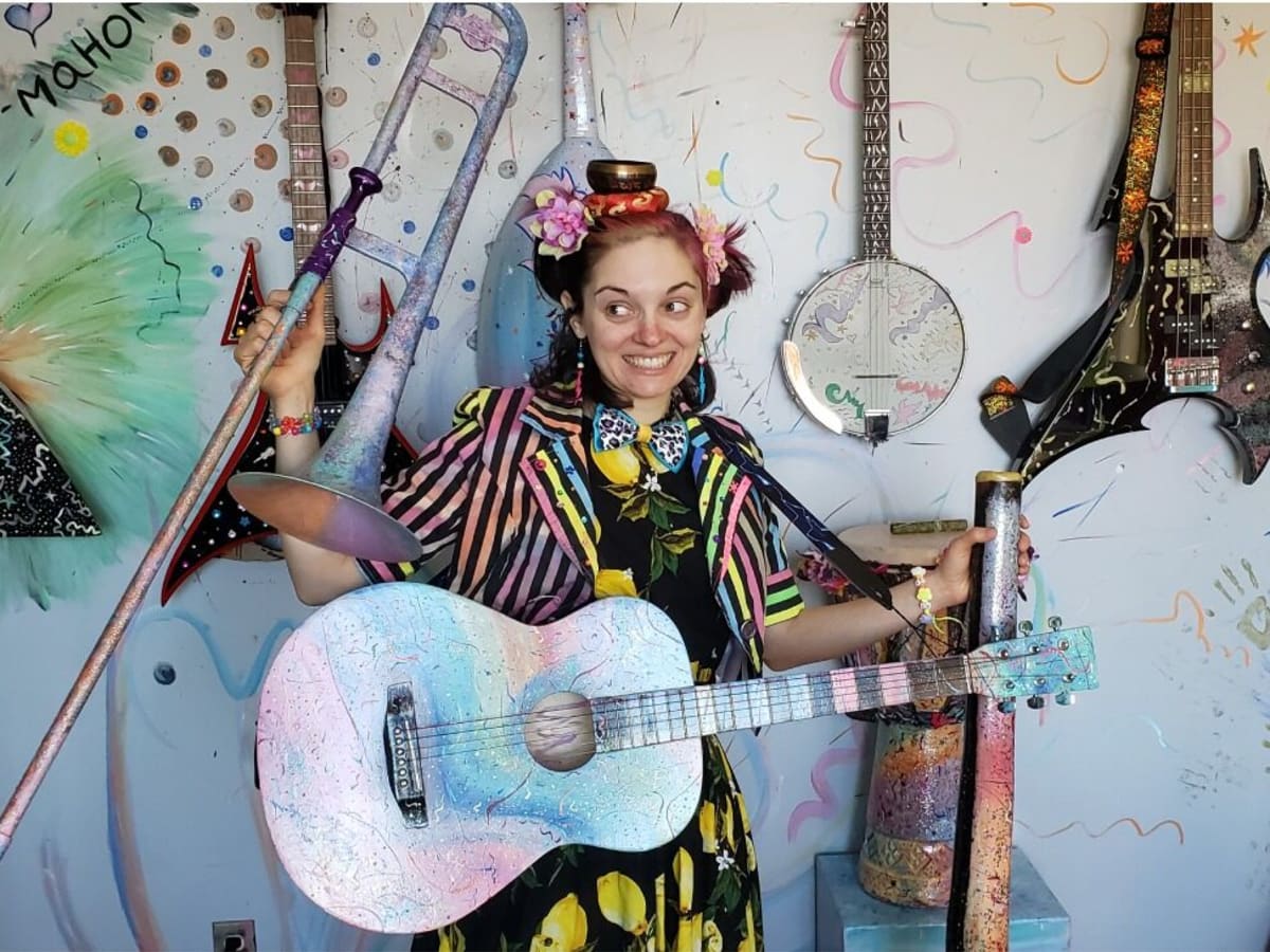 Fille déguisée et souriante entourée d'un décor d'instruments de musique
