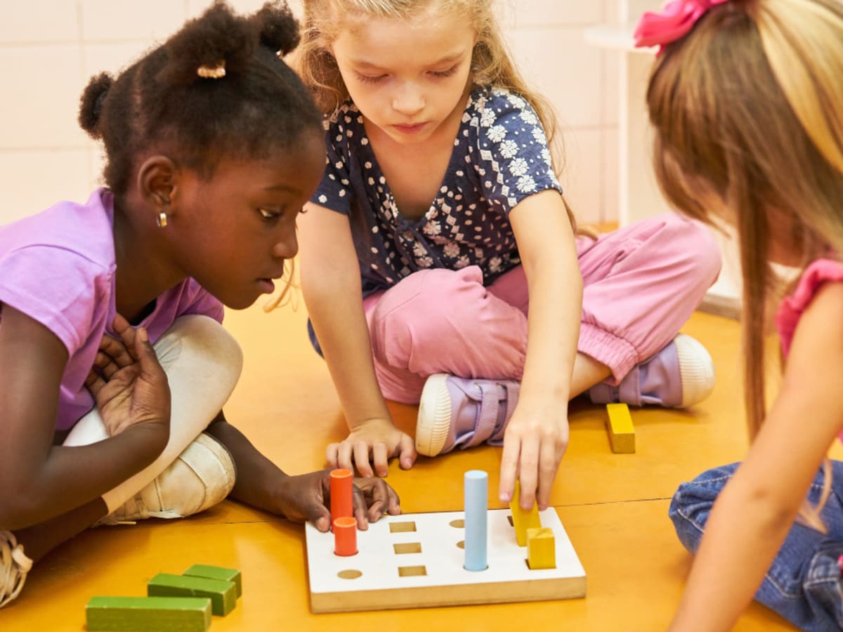 Photographie de trois enfants jouant à un jeu de société
