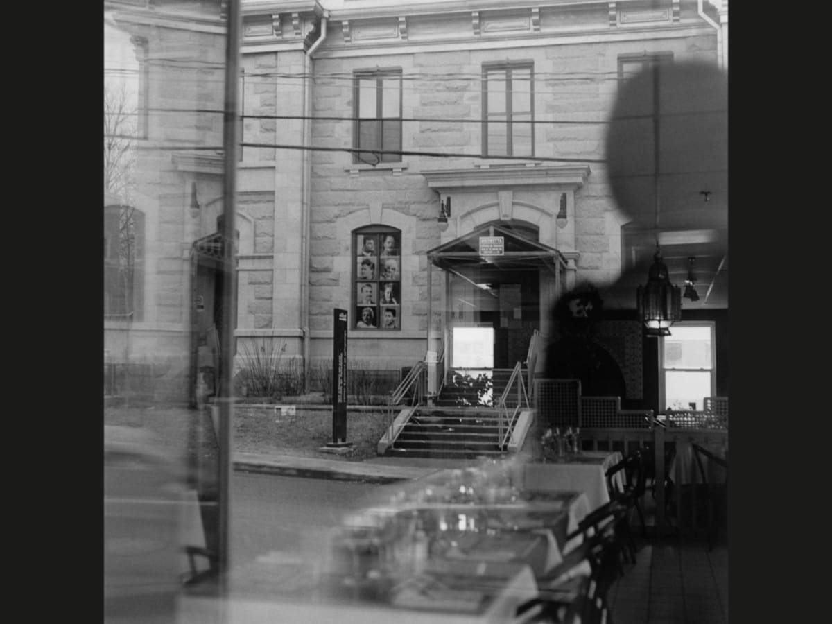 Image en noir et blanc d'un musée fondu avec l'ombre du photographe.