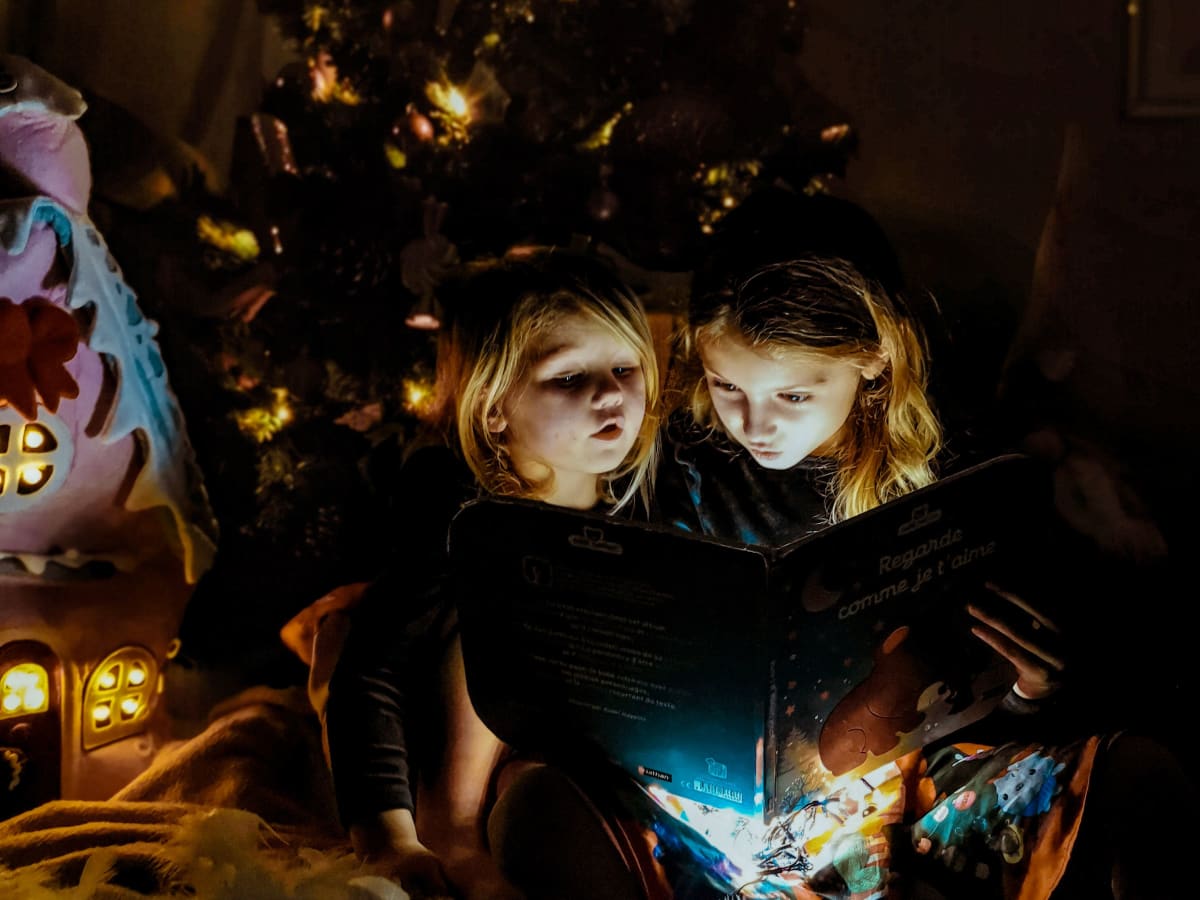 deux jeunes filles qui lisent un livre dans le noir