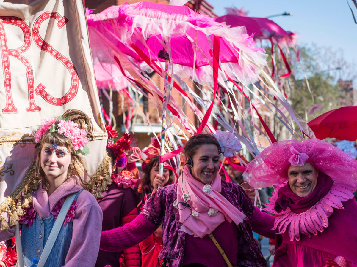 Dans une ambiance festive et inclusive, trois artistes en costumes roses déambulent sur le domaine public.