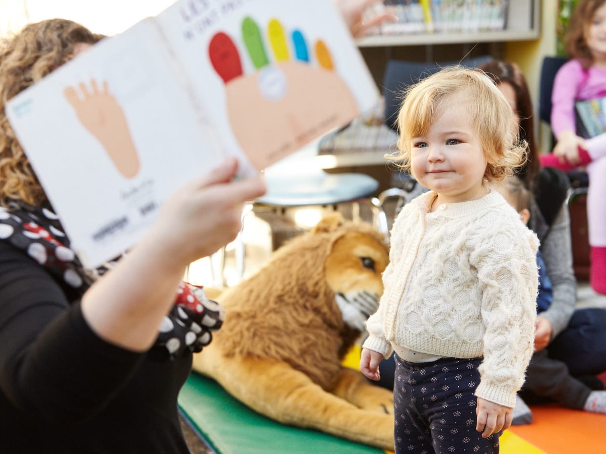 Un bébé qui regarde quelqu'un caché par un livre