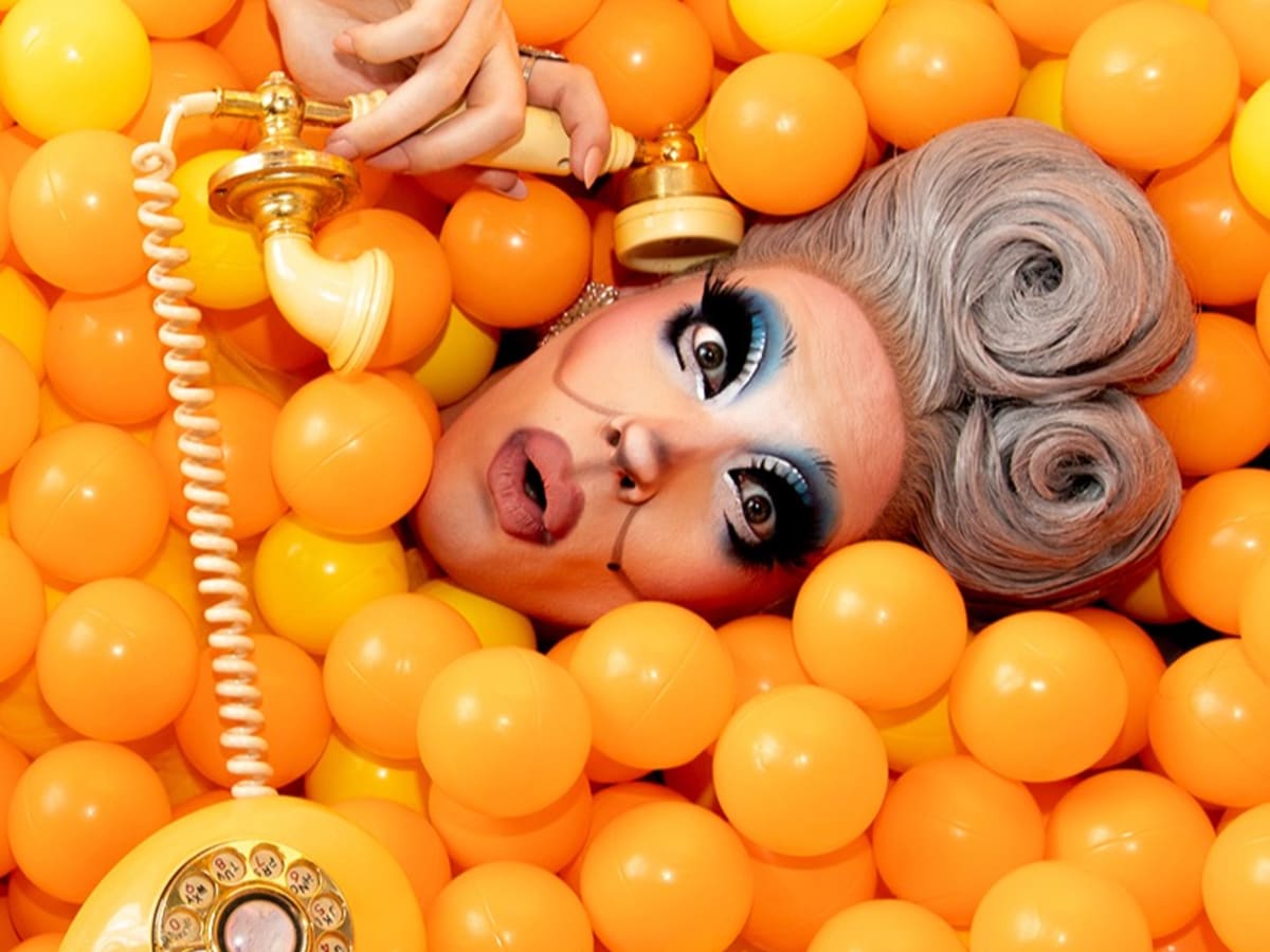 Photo de Uma Gahd au téléphone et ensevellie sous des balles orange