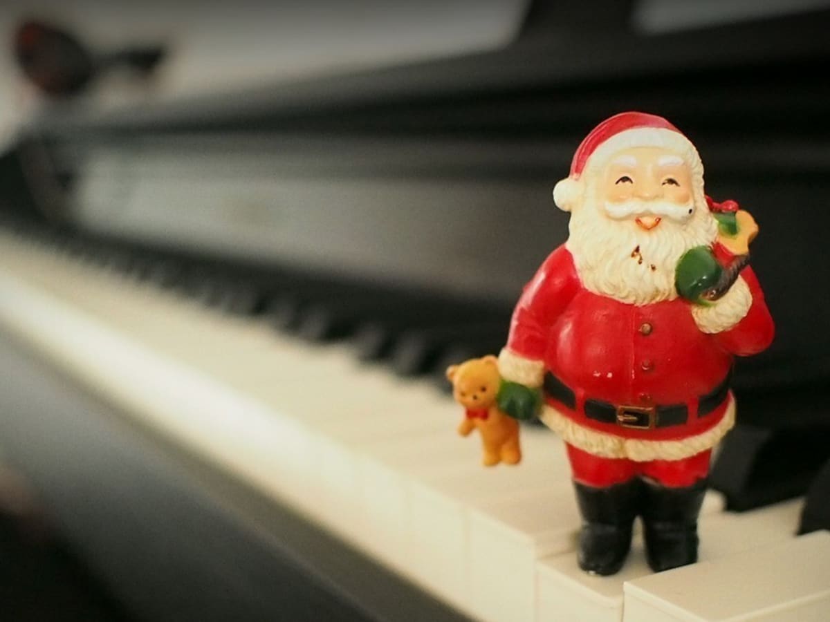 Une figurine de Père-Noël sur le clavier d'un piano.