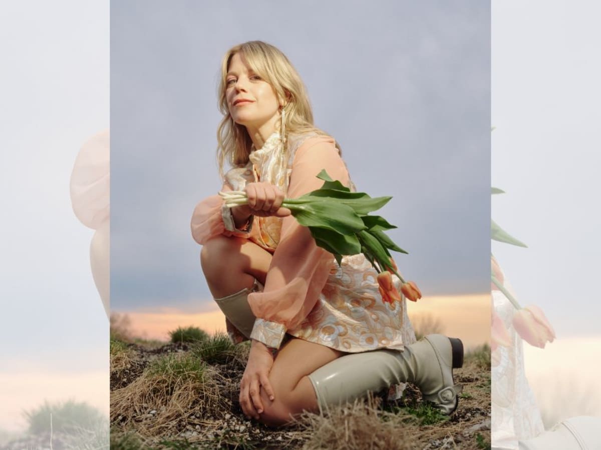 Basia Bulat à genous avec un bouquet de tulipes