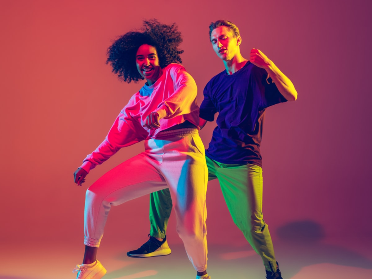 Deux personnes en train de danser sous un éclairage coloré.