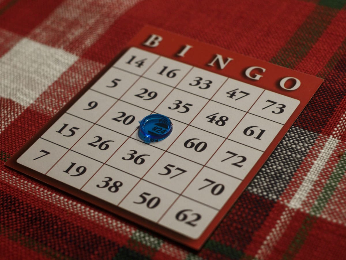 Image d'une planche de bingo rouge et blanche avec un jeton bleu au centre sur l'espace Gratuit