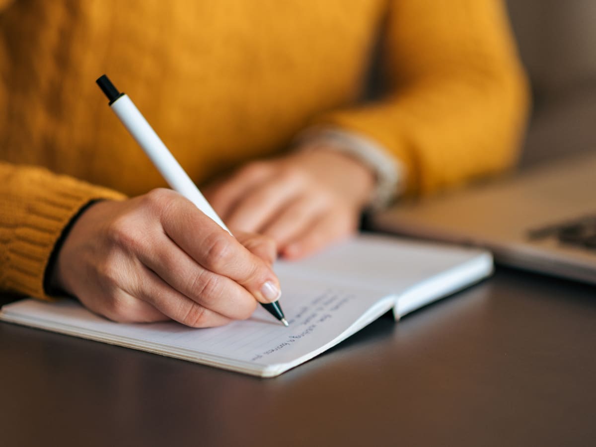 Une main qui écrit dans un cahier