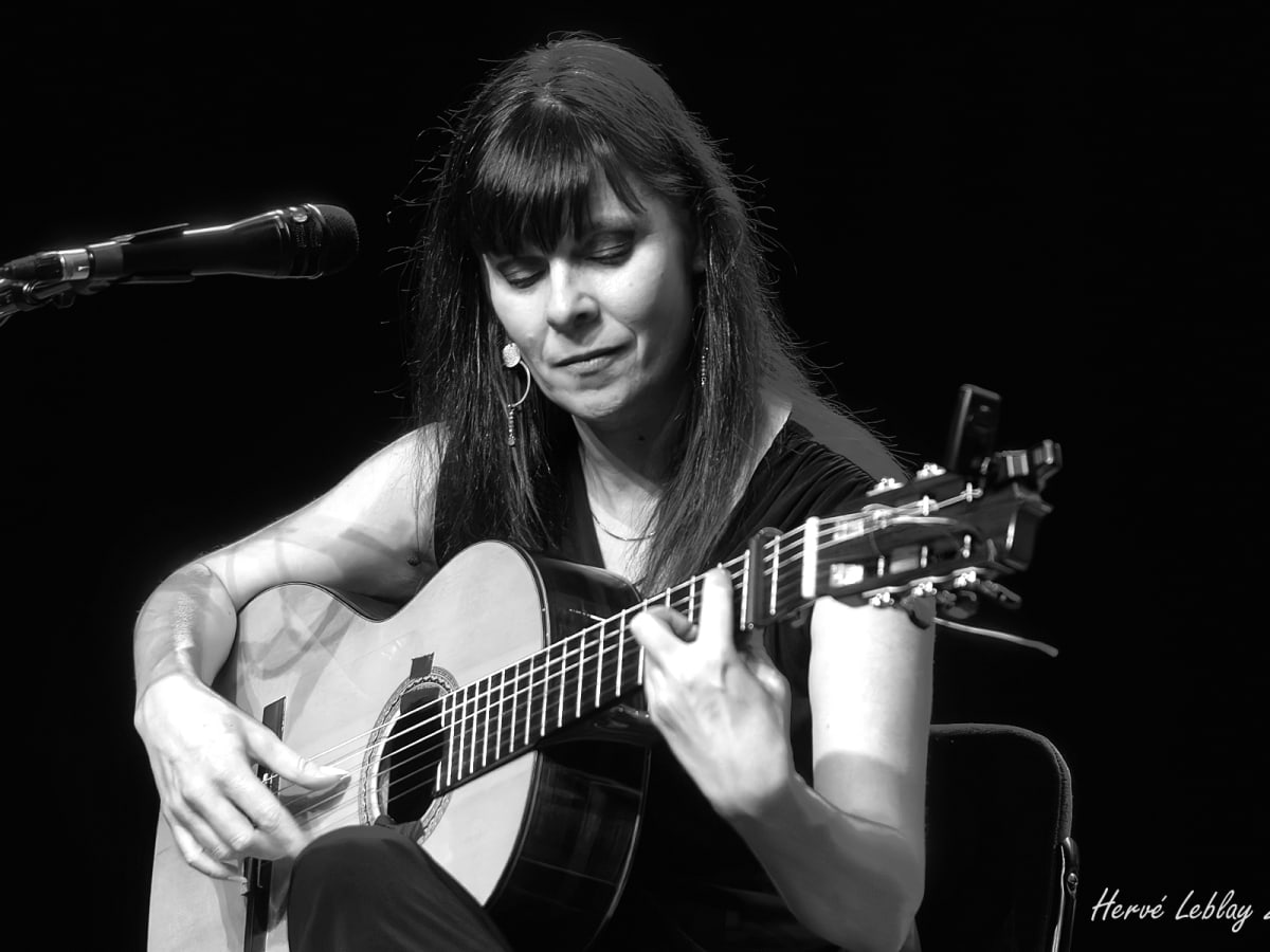 Femme avec guitare et micro, photo en noir et blanc