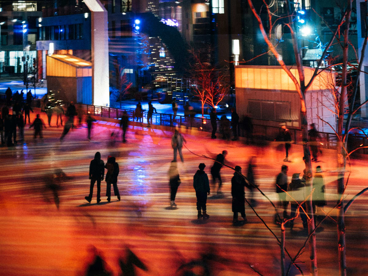 Des personnes font du patin le soir au centre-ville de Montréal