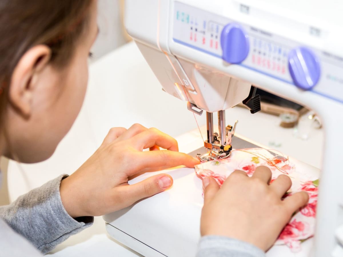 Un jeune fille qui utilise une machine à coudre
