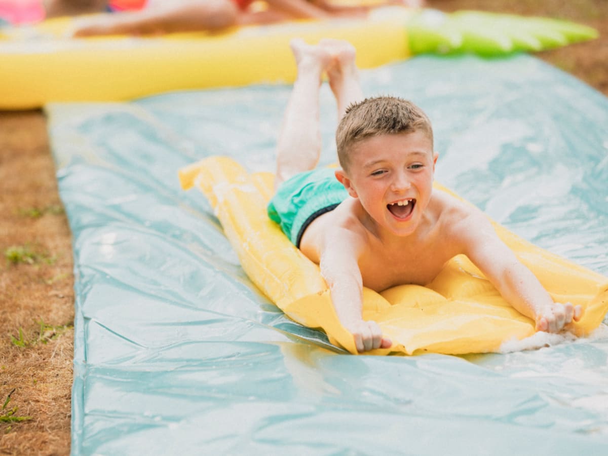 Photo d'un enfant glissant sur un tapis d'eau