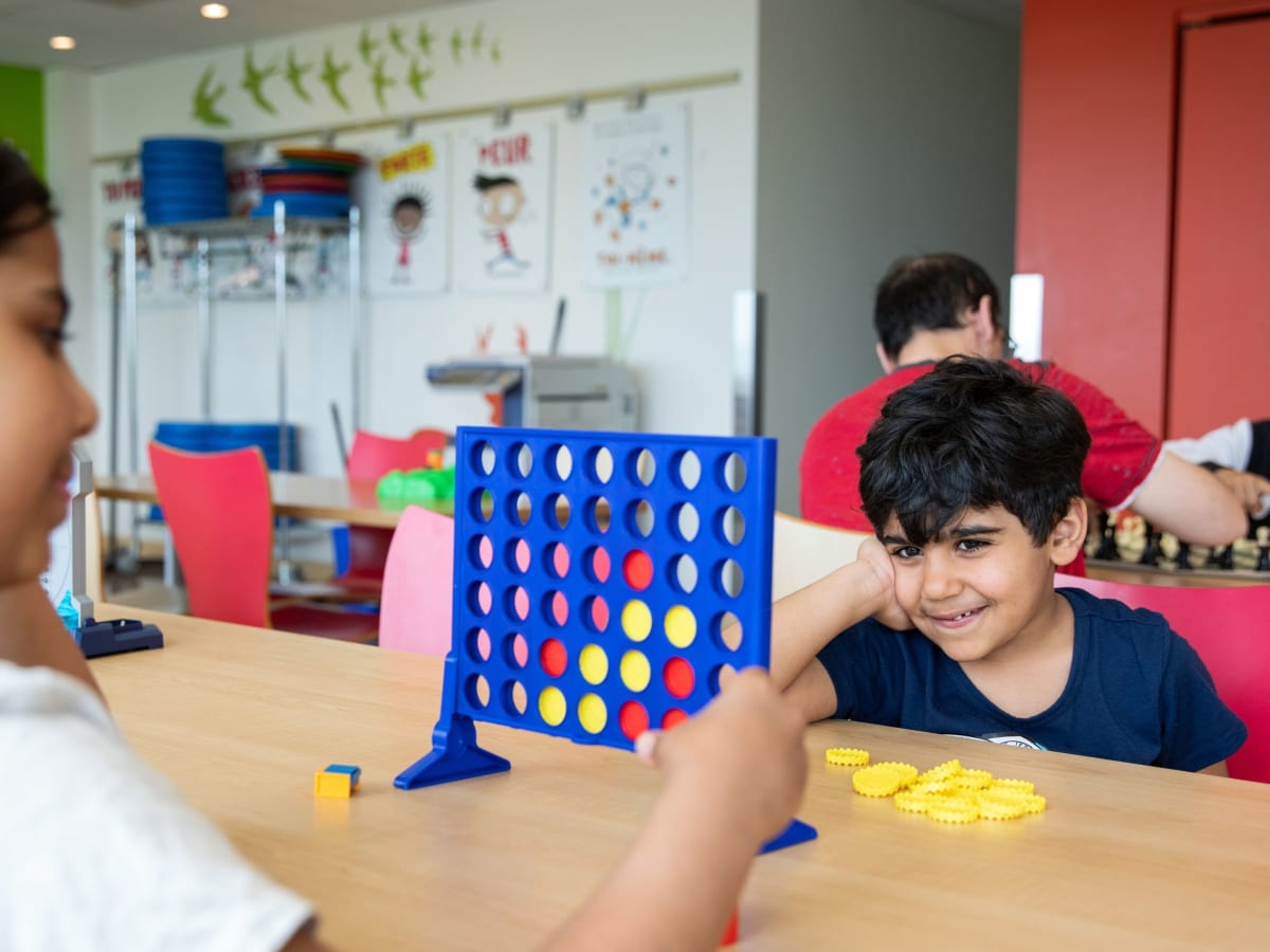 Des personnes qui jouent à des jeux de société dans une bibliothèque.