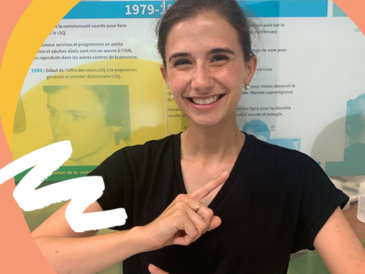 Photo d'une femme blanche souriante portant un t-shirt noir qui gesticule avec ses mains