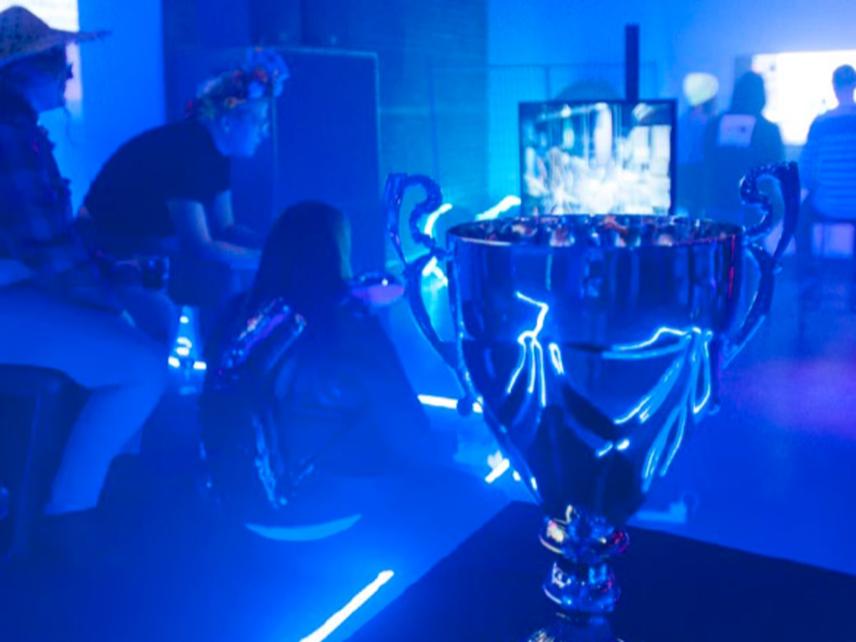 Photo de joueurs de jeux vidéo avec un trophée à l'avant plan
