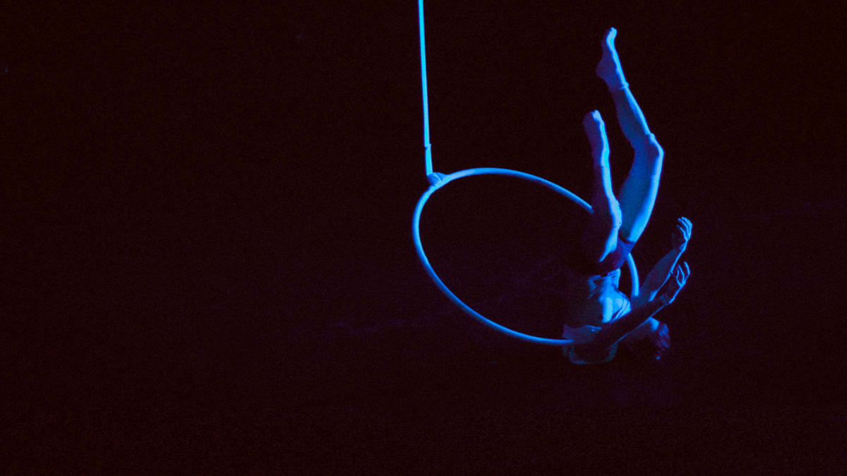 Acrobate suspendu dans un cerceau.