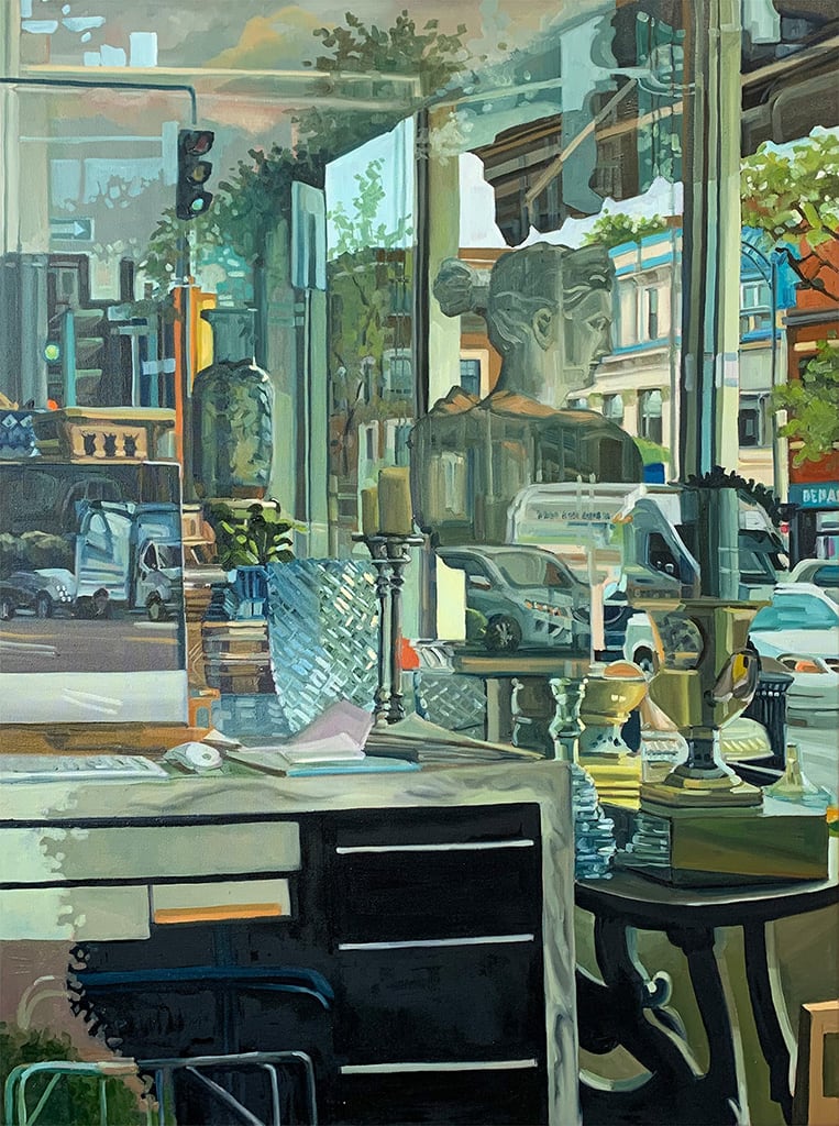 À l'intérieur d'une boutique de bibelots, la vitrine donne sur un paysage urbain marqué par les voitures et immeubles.