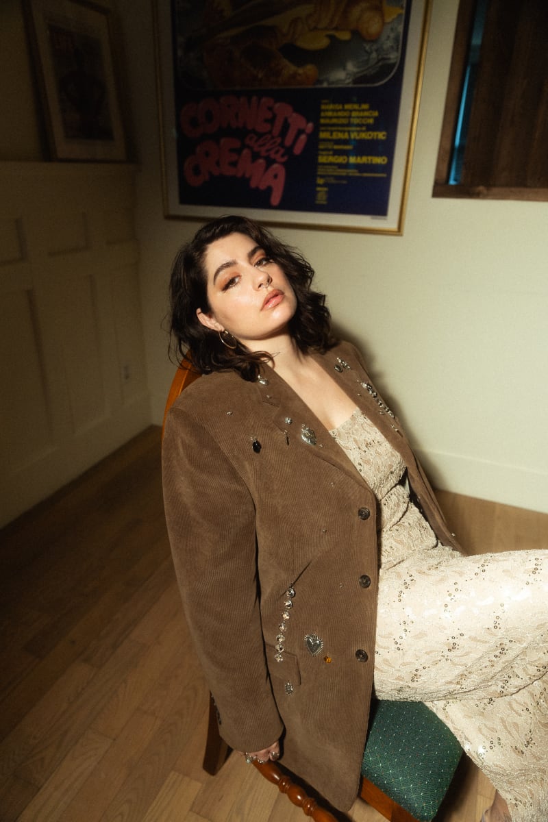 La chanteuse Léonie Gray est assise sur une chaise et regarde vers la caméra.