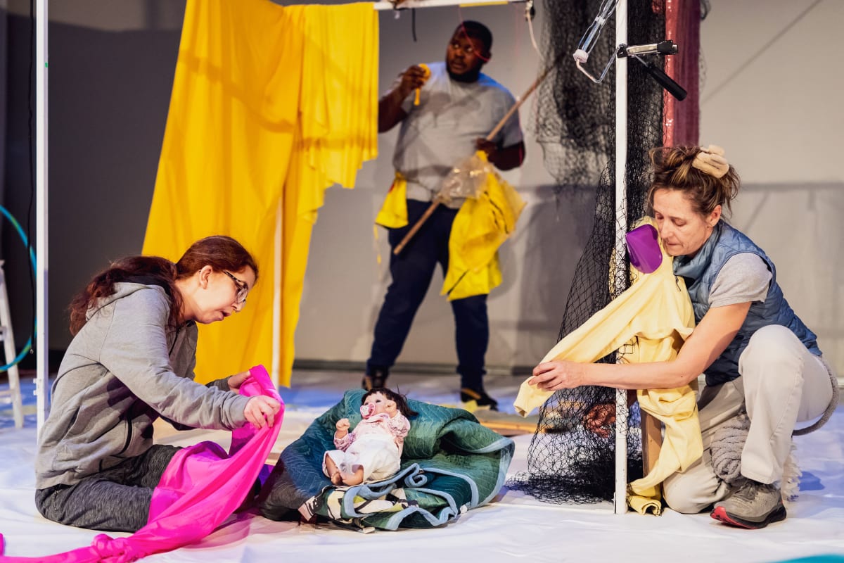 Scène artistique avec tissus colorés et poupée au sol