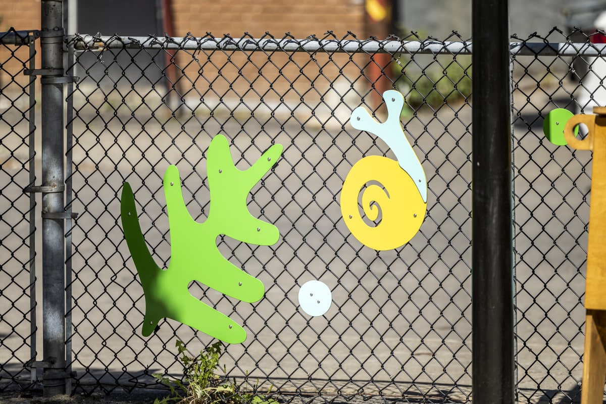 Photos d'éléments en aluminium sur la clôture du parc représentant un escargot et une plante
