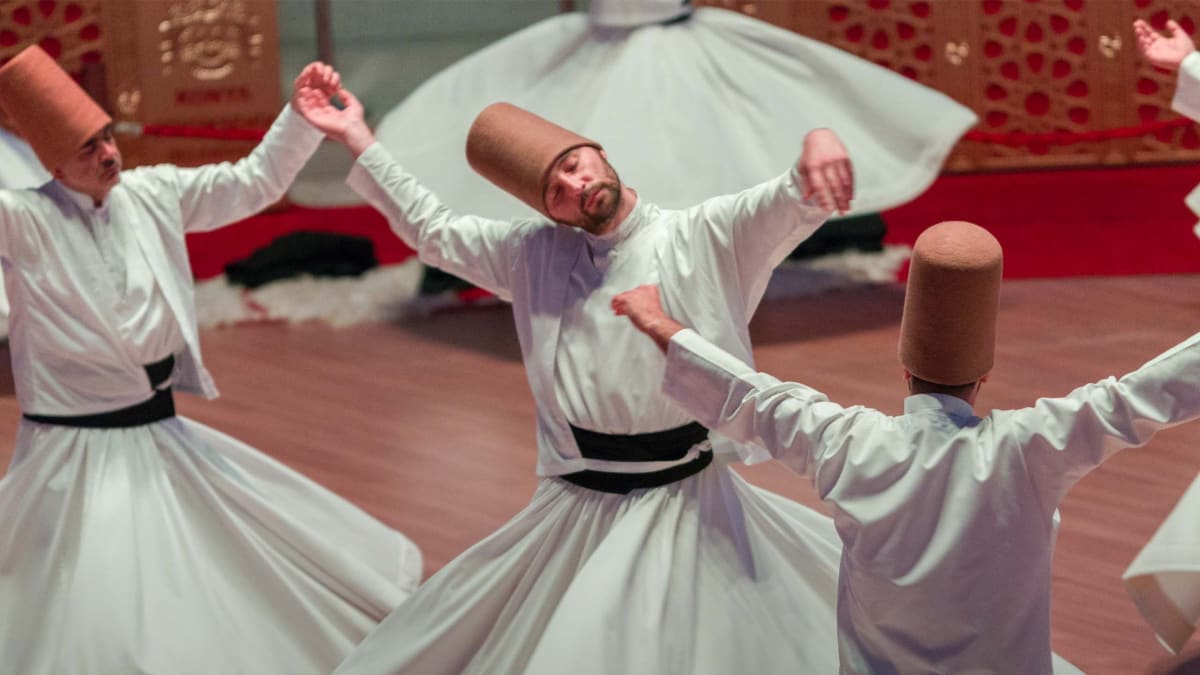 Trois hommes dansent en costume traditionnel