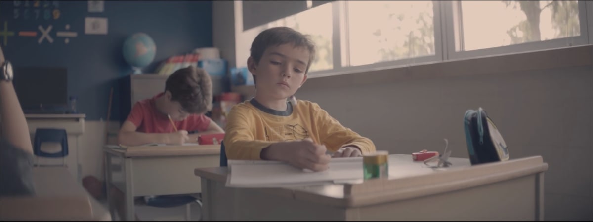 Image d'une garçon sur un banc d'école tirée du film Émetteur récepteur