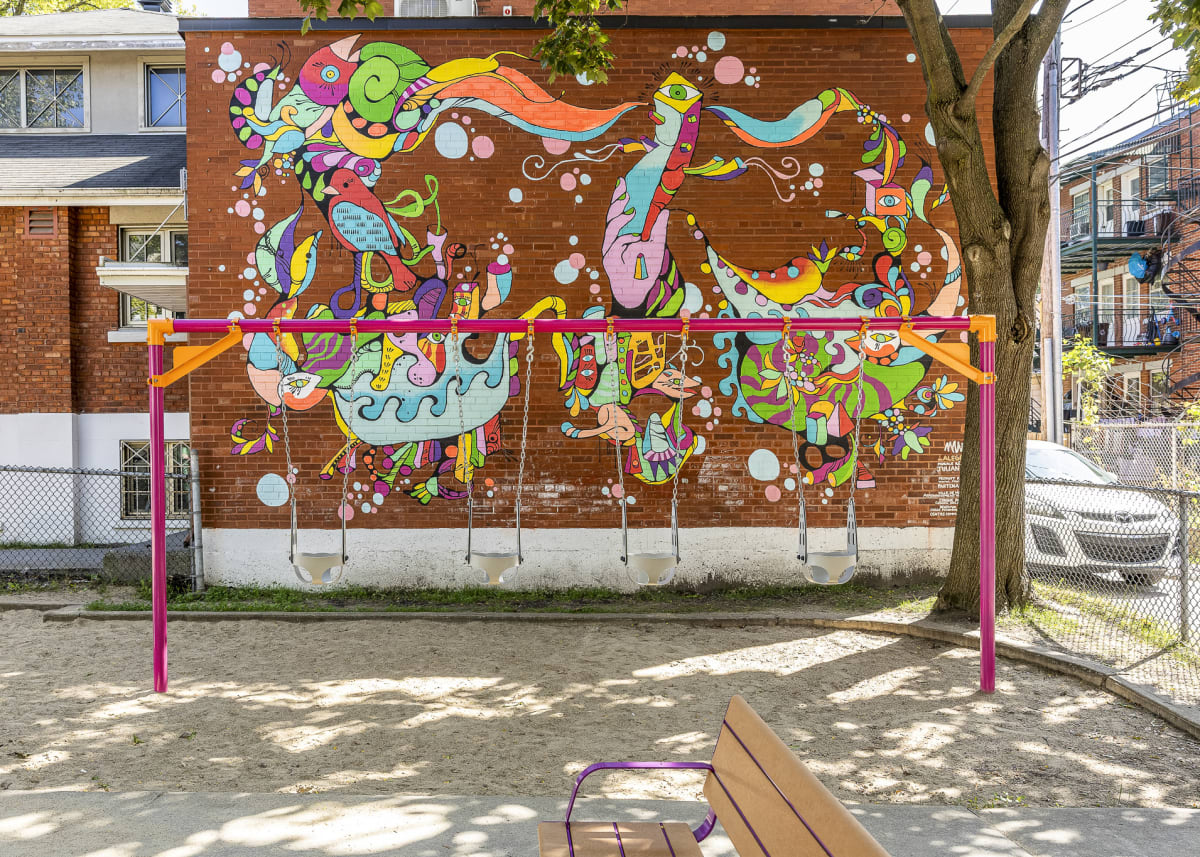 Photo montrant les balançoires avec le portique en métal rose. Au fond, on aperçoit une murale colorée représentant des oiseaux.