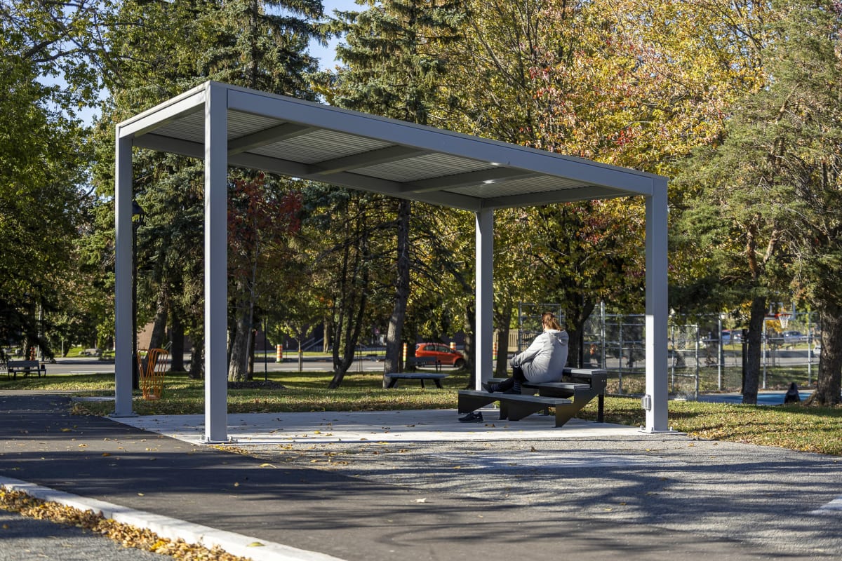 Photo de l'abri muni d'une estrade sur laquelle une femme prend une pause en plein air