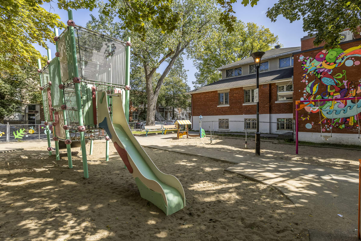 Photo de la glissoire aux tons pastel dans la carré de sable du parc
