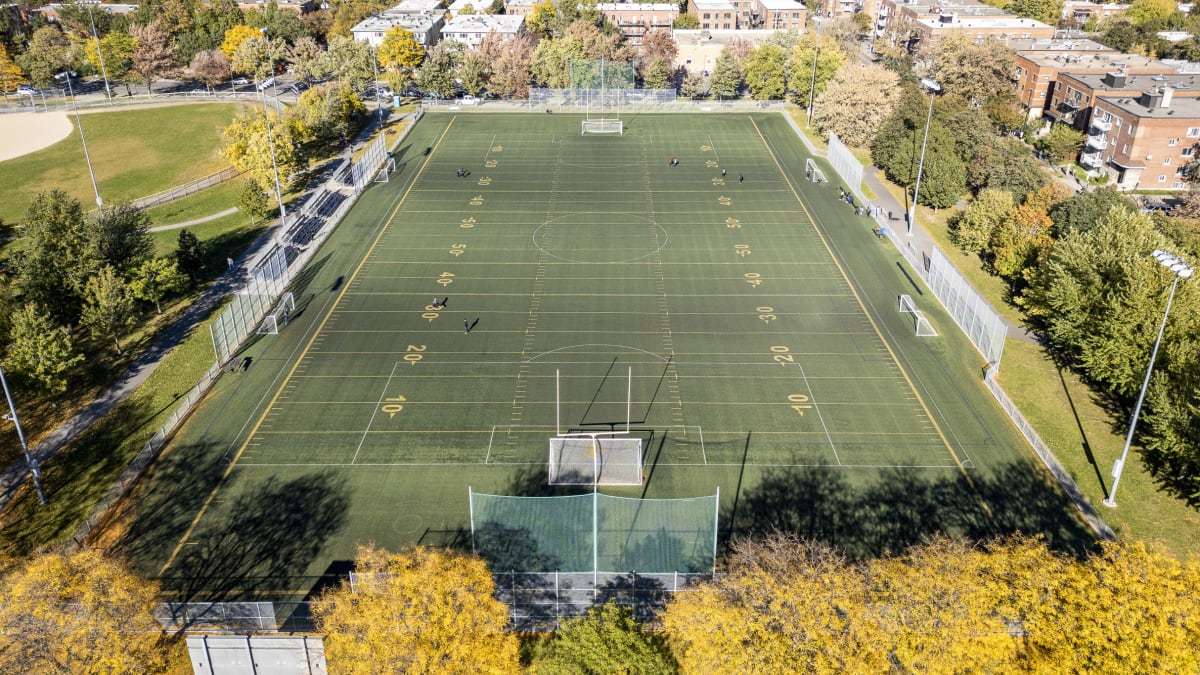 Photo aérienne montrant un grand terrain de sport avec du marquage, des poteaux et des cages de but pour pratiquer le soccer et le football américain.