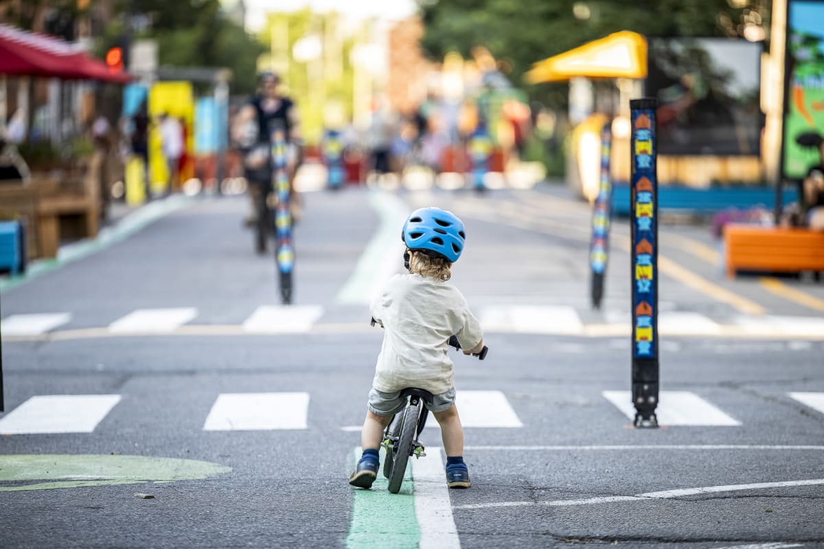 Photo montrant un tout-petit circulant en draisienne sur la rue piétonne