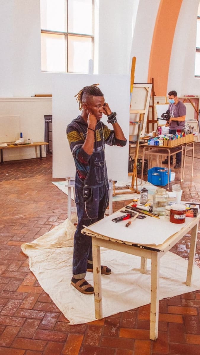 Artiste dans un atelier entouré d'outils et toiles