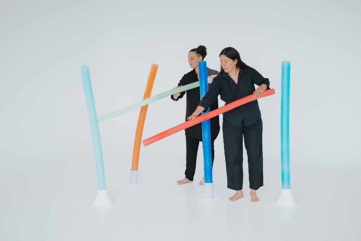 Deux artistes manipulent des tubes de couleur