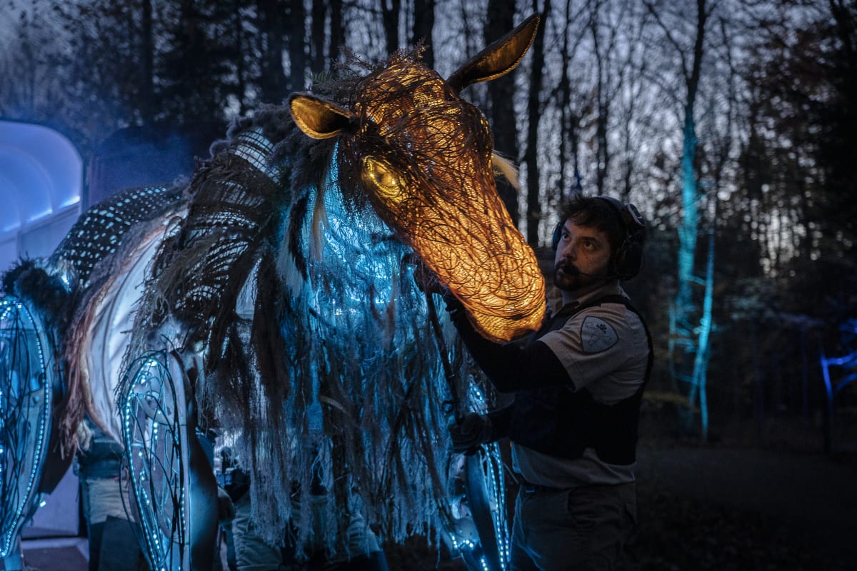Homme à côté d'un animal artificiel.