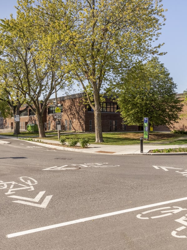Photo d'une intersection aux abords d'une école primaire qui a été réaménagée avec des saillies de trottoir et des pistes cyclables pour favoriser les transports actifs et sécuritaires.