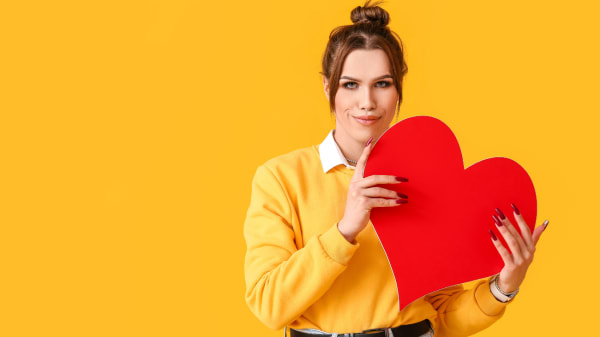 Une femme tient un coeur en carton rouge