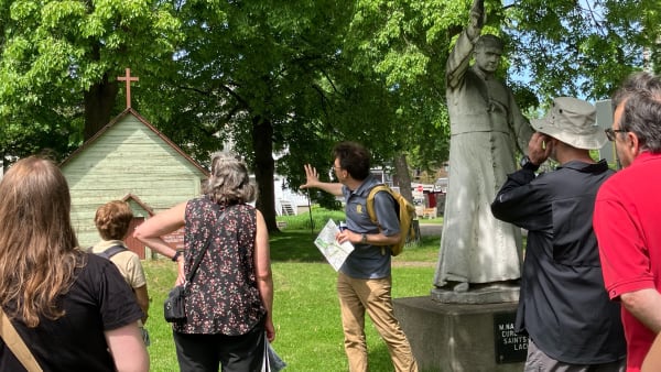 Un guide donne des explications sur un bâtiment à un petit groupe.