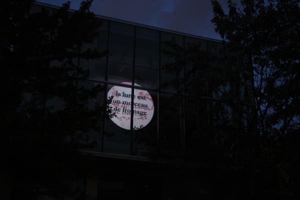 Une lune générée électroniquement est projetée sur la façade d'un bâtiment