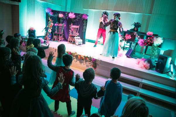 Des artistes déguisés en créatures halloweenesques amusent les enfants sur scène.