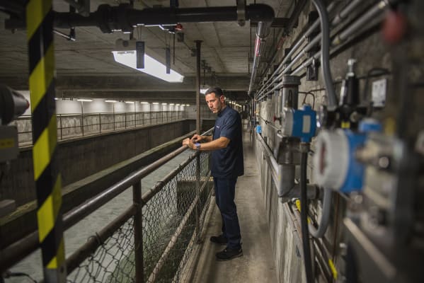 Amir devant le déversoir où l'eau est débarrassée des particules en suspensions