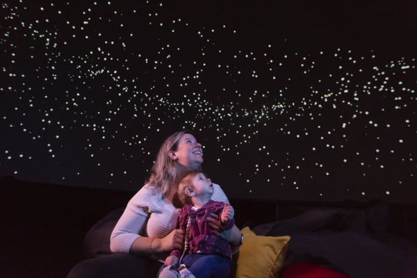 Femme avec son enfant regardant un ciel étoilé