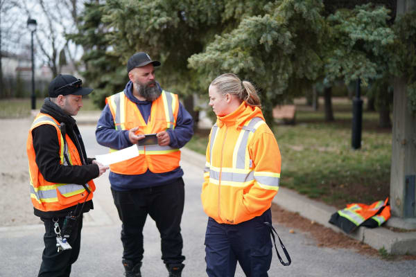 Trois cols bleus en train de travailler près d'un parc